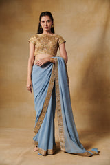 Powder blue georgette saree with all over gold blouse