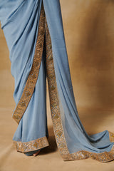 Powder blue georgette saree with all over gold blouse